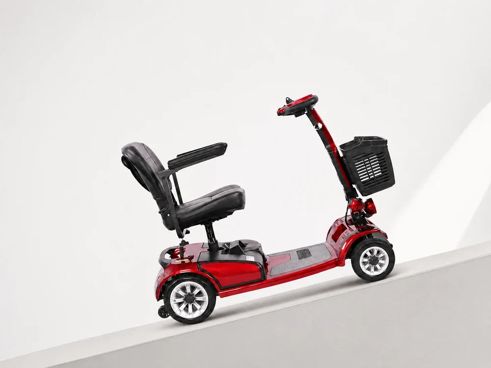 FoldScoot red mobility scooter climbing an incline with rear anti-roller wheels